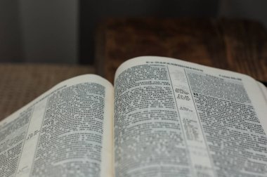Incil açık kitap ahşap bir yüzey üzerinde yatıyor.