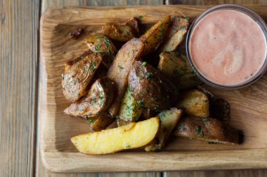 Ahşap bir yüzey üzerinde kızarmış patates dilimleri.