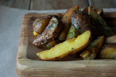 Ahşap bir yüzey üzerinde kızarmış patates dilimleri.