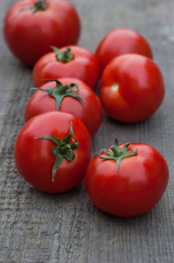 Ahşap arka plan üzerinde birkaç sulu kırmızı domates.