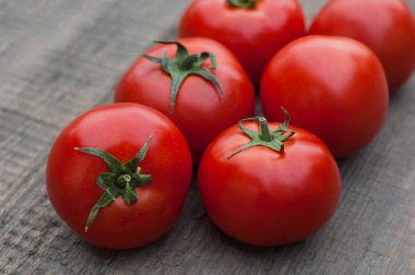 Ahşap arka plan üzerinde birkaç sulu kırmızı domates.