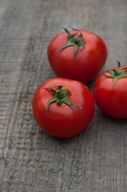 Ahşap arka plan üzerinde birkaç sulu kırmızı domates.