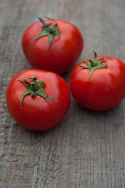 Ahşap arka plan üzerinde birkaç sulu kırmızı domates.