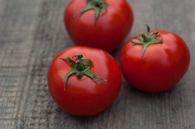 Ahşap arka plan üzerinde birkaç sulu kırmızı domates.