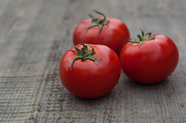 Ahşap arka plan üzerinde birkaç sulu kırmızı domates.