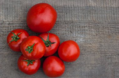 Ahşap arka plan üzerinde birkaç sulu kırmızı domates.