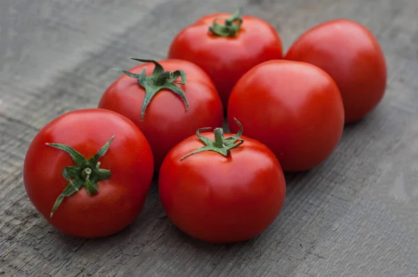 Ahşap arka plan üzerinde birkaç sulu kırmızı domates.