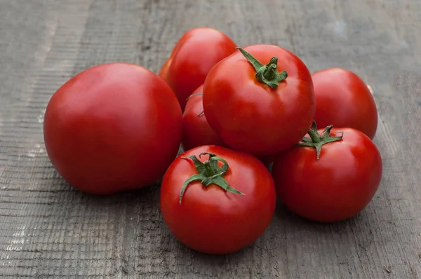 Ahşap arka plan üzerinde birkaç sulu kırmızı domates.