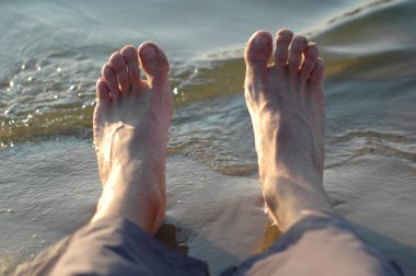 Erkek bacaklar dalgalar deniz arka planı.