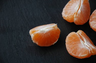 Siyah bir zemin üzerine birkaç mandalina yakın çekim.