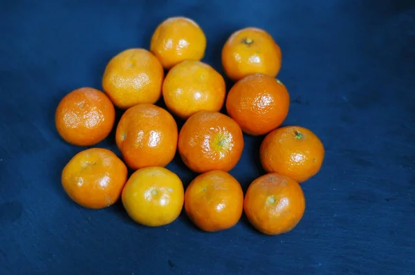 Mandarin Yang Tidak Dikupas Pada Latar Belakang Gelap Dengan Cahaya — Stok Foto