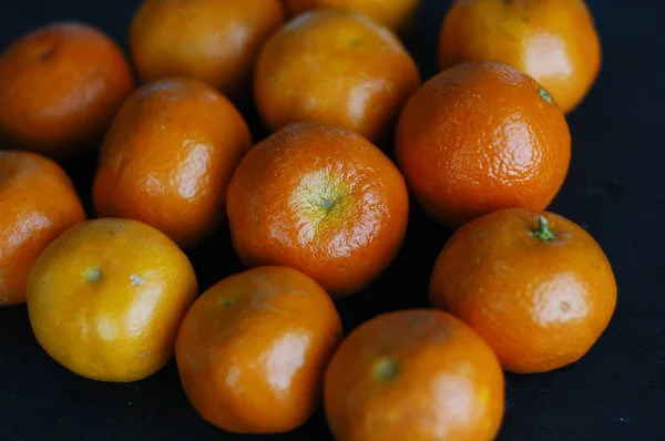 Mandarin Yang Tidak Dikupas Pada Latar Belakang Gelap Dengan Cahaya — Stok Foto