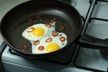 Tavada biberli iki kızarmış yumurta.