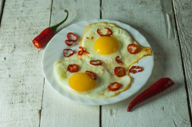 Beyaz masada biber ile iki kızarmış yumurta.