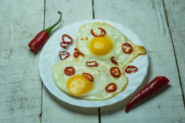 Beyaz masada biber ile iki kızarmış yumurta.