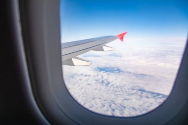 Uçak kanadı ve bulutlar lombozdan görülebilir..