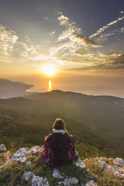 바다 위의 산에서 여자 노란색 일출에 앉아 — 스톡 사진