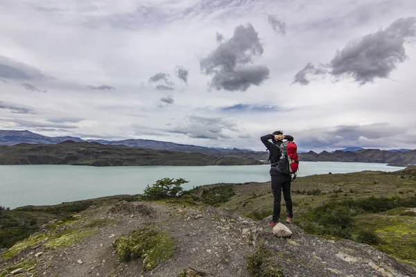 파 타고 니 아에서 호수 위에 돌에 서 있는 배낭과 소녀 — 스톡 사진