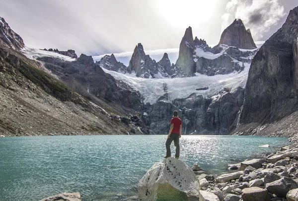 Mens staande op de steen boven lake in de buurt van fitz roy berg, Patagonië — Stockfoto