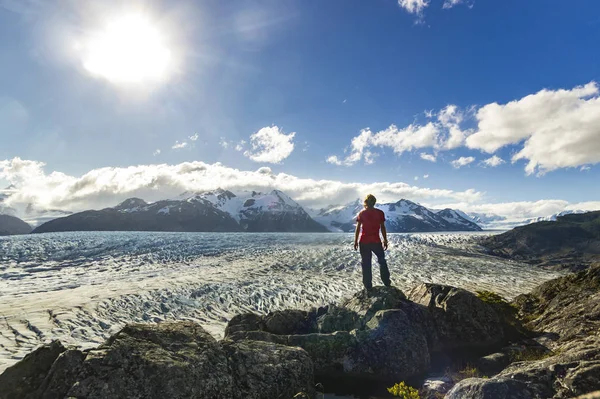 Ember áll a kő fölött szürke gleccser Patagonia naplementekor — Stock Fotó