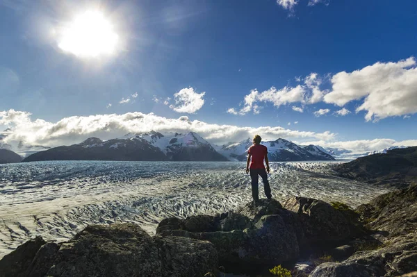 Man standing on the stone above Grey glacier in patagonia at sunset — Stock Photo, Image