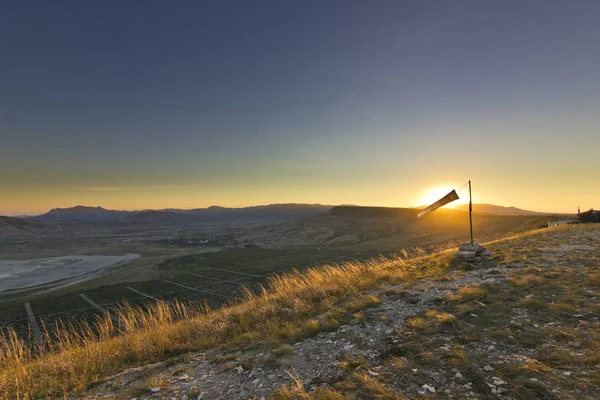 Windsock ao pôr do sol nas montanhas contra o sol — Fotografia de Stock