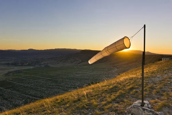 Windsock saat matahari terbenam di pegunungan terhadap matahari — Stok Foto