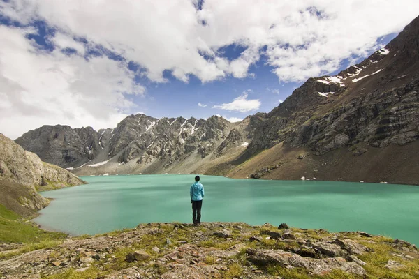 Lány a kék kabát állandó kék tó körül hegyek felett — Stock Fotó