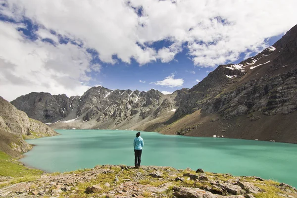 Ragazza in giacca blu in piedi sopra il lago blu con montagne circondate — Foto Stock