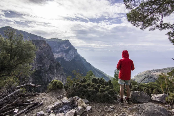 Mann auf der Klippe in den Bergen über dem Meer — Stockfoto