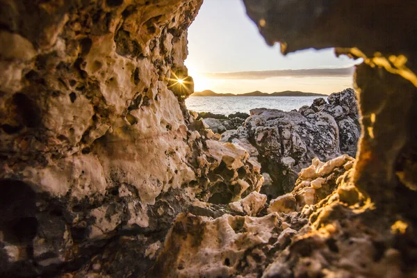 Uitzicht vanaf hole in steen op vulkanische strand omgeven door bergen bij zonsopgang — Stockfoto