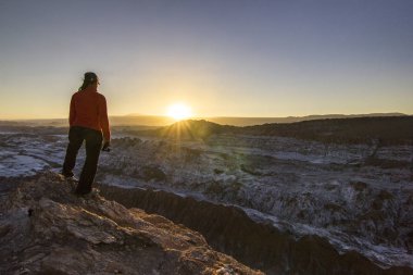 Kız atacama Çölü'nde tuzlu ayın Vadisi'nde bir uçurumun üzerinde günbatımında ayakta