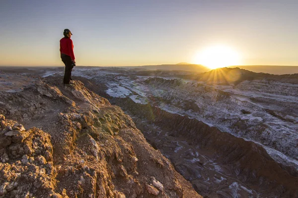 Girl standing on a cliff in salty Moon valley in atacama desert at sunset — Stock Photo, Image