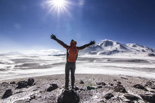 Man standing with hands up near ojos del salado volcano in chile — Stock Photo, Image