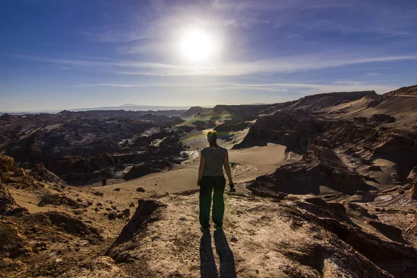 Chica de pie en un acantilado en el valle de la Luna salada en el desierto de atacama al atardecer — Foto de Stock