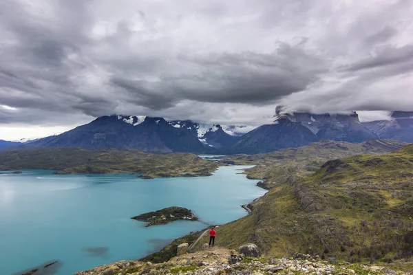 Mädchen in roter Jacke in den Bergen Patagoniens im Dunst bei Sonnenaufgang am blauen See — Stockfoto