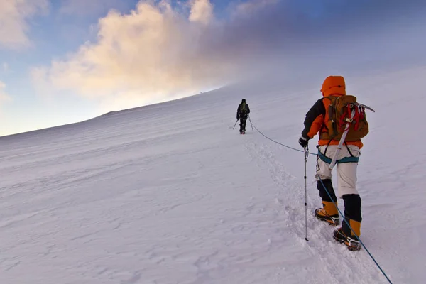 Uomo che si arrampica sul pendio di neve della montagna kazbeka nel Caucaso — Foto Stock