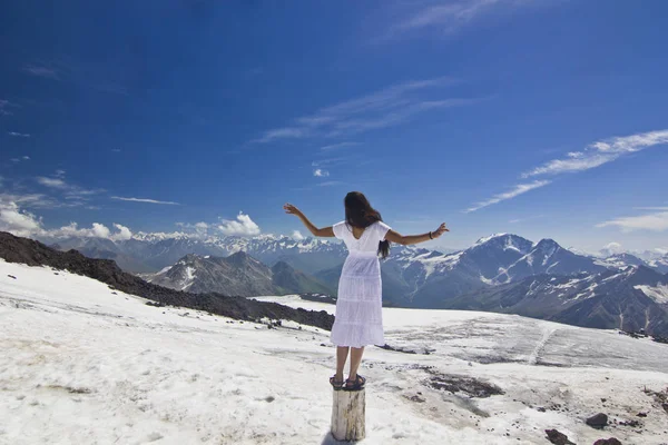 산에서 손을 최대 눈 슬로프에 하얀 드레스를 입고 서 있는 여자 — 스톡 사진
