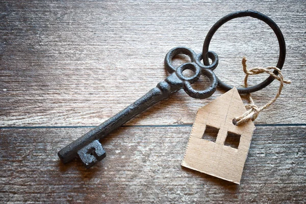 Vecchia chiave in metallo con simbolo di una casa di famiglia — Foto Stock