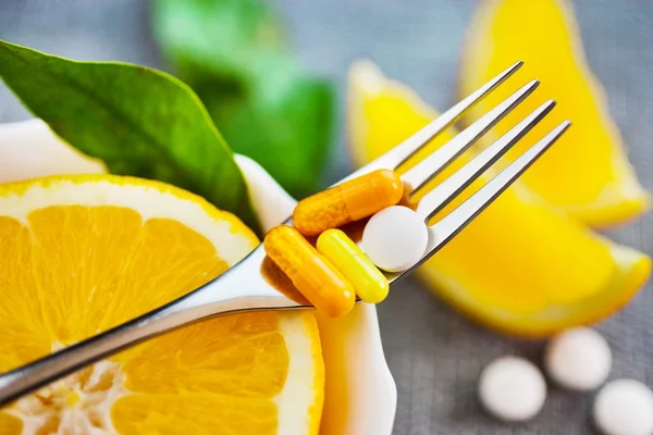 Cuidados de saúde e bem-estar - fruta de laranja fresca e vitamina C como comprimidos, agarramento e prevenção de outras doenças — Fotografia de Stock