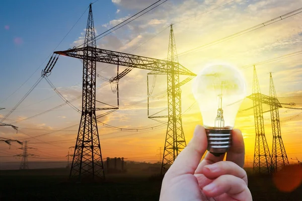 Elektrické energie - ruka drží zářící ochrany životního prostředí žárovky - energetické úspory a výdaje koncepce- — Stock fotografie