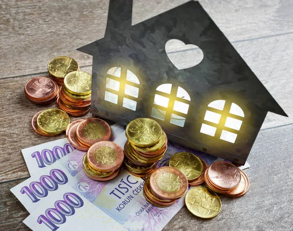 Economy and finance - a family house and energy expenses with shining windows with money — Stock Photo, Image
