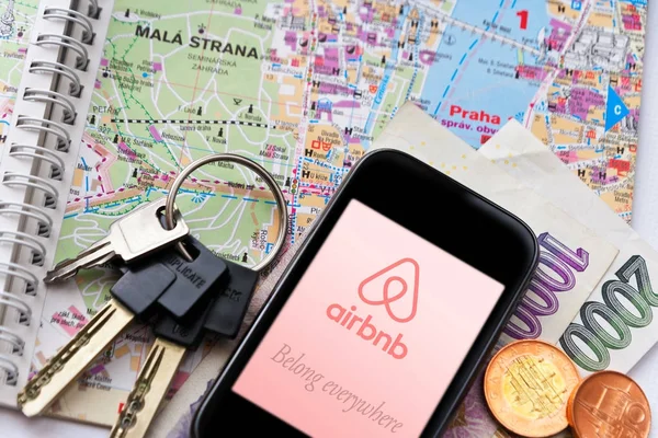 Compartir la economía en los viajes - Aplicación Airbnb en el teléfono inteligente - con las llaves y el mapa de Praga — Foto de Stock