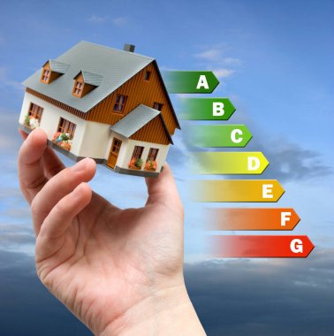 Enerji verimliliği etiketi house için / Isıtma ve para tasarruf - model bir evin içinde bir el