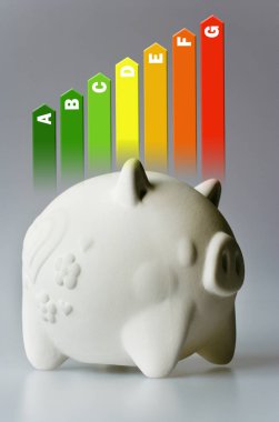 Enerji verimliliği etiketi house için / Isıtma ve para tasarruf - piggy banka gri arka plan üzerinde