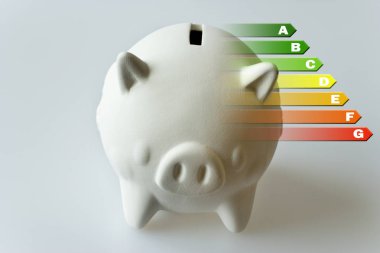 Enerji verimliliği etiketi house için / Isıtma ve para tasarruf - piggy banka gri arka plan üzerinde