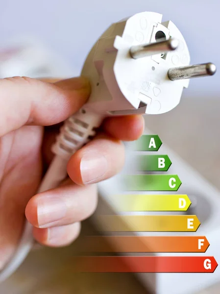 Energy efficiency label for house / electricity and money savings - plug in a hand