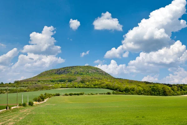 Colina mística nacional Rip, Bohemia Central, República Checa - paisaje de primavera con campos verdes y cielo azul con nubes — Foto de Stock