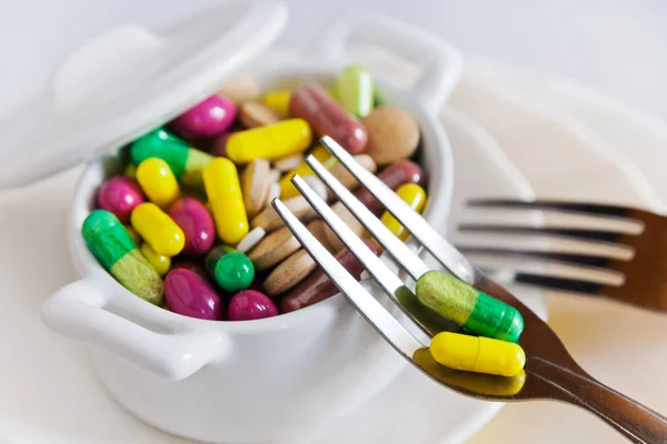 Cuidados de saúde e bem-estar - pílulas de dieta e perder peso - vários comprimidos em um pote com garfos — Fotografia de Stock