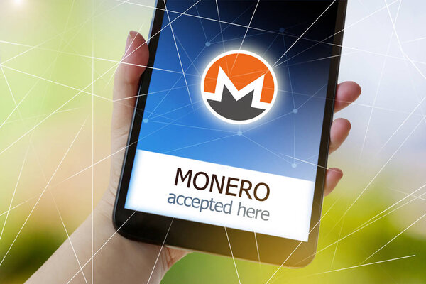 виртуальные деньги криптовалюта на экране смартфона в руке - Monero принимается здесь
